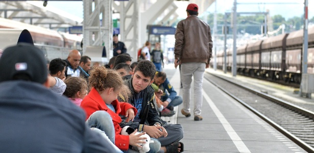Refugiados esperam chegada de trens com direção à Alemanha na estação de Salzburgo