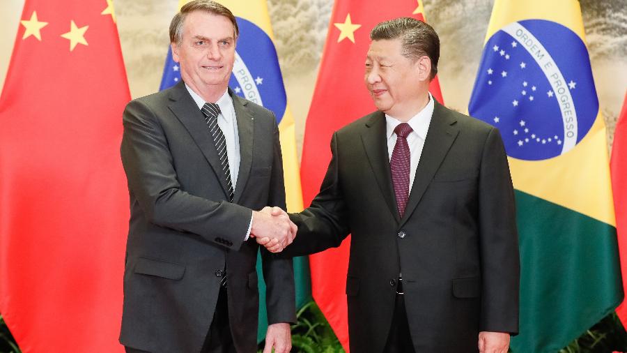 25.out.2019 - O presidente brasileiro Jair Bolsonaro cumprimenta o presidente chinês Xi Jinping durante sua viagem ao país asiático