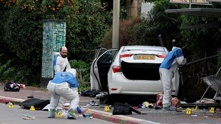 15.jan.24 - Pessoas trabalham ao lado de um veículo após ataque em Raanana, Israel