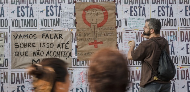 27.mai.2016 - Manifestantes colam cartazes contra machismo e violência sexual no tapume que cerca obras no Masp, na avenida Paulista, região central de São Paulo