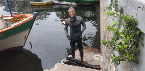 Mayko Vieira procura sem sucesso por notas de R$ 100 e R$ 50 que desde domingo vêm sendo encontradas no mar da Urca