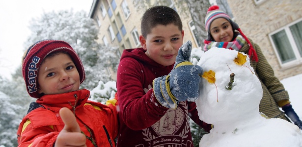 14.out.2015 - Jovens sírios brincam com boneco de neve após nevasca em na Alemanha, país que recebeu milhares de refugiados e onde hoje tudo é possível. Os EUA, tomados pelo medo, passaram a tocha