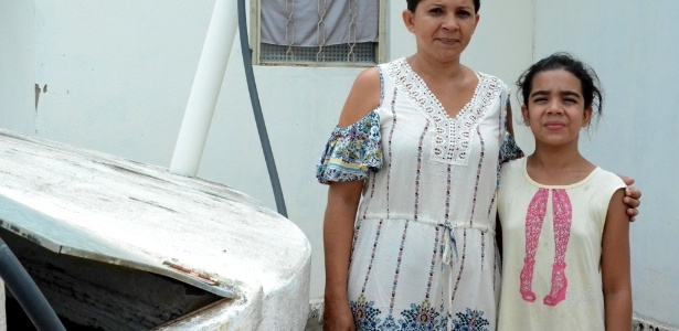 Teodora Maria Dantas, 39, e a filha, Keyla Beatriz, 12, acumulam água em cisterna com abertura em Palmeira dos Índios (AL)