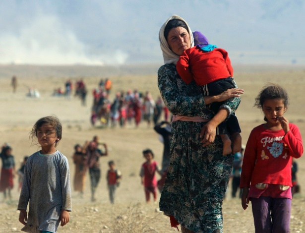 Refugiados da minoria Yazidi fogem diante da aproximação do EI de Sinjar, na Síria