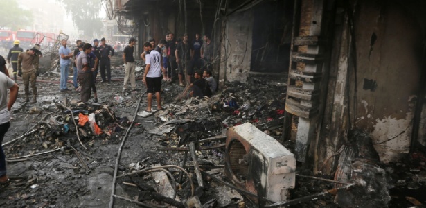 Sabah Arar/AFP Iraquianos inspecionam local onde dezenas de pessoas morreram após atentado