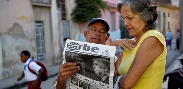 Cubanos leem jornal com capa sobre a vitória de Donald Trump em rua de Havana