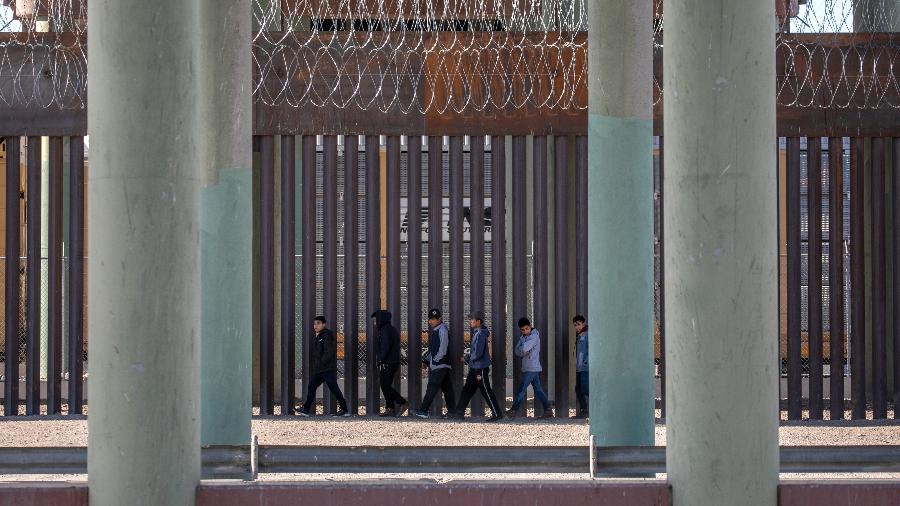 17 mar. 2021 - Migrantes sem documento caminham ao longo de muro na fronteira EUA-México depois de correrem no rio Grande, na Ciudad Juarez, México