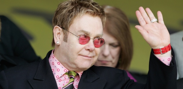 Elton John acena para o público durante um jogo do Watford; cantor já foi dono e é presidente honorário do clube inglês