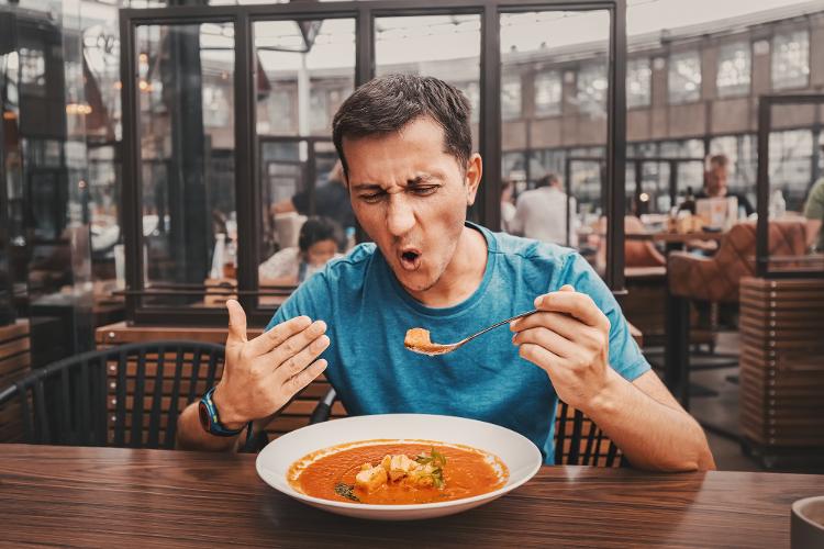 Homem prova comida com pimenta