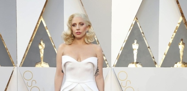 Lady Gaga posa no tapete vermelho do Oscar com um vestido longo branco