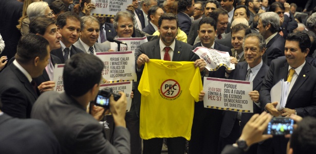 Deputados da bancada do PSDB mostram cartazes contrários à PEC 37 em sessão de votação nesta terça-feira (25), em Brasília