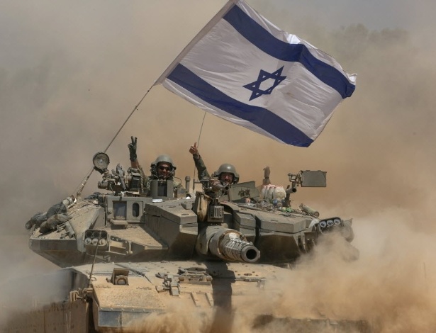 Soldados israelenses circulam em um tanque na Faixa de Gaza em agosto de 2014