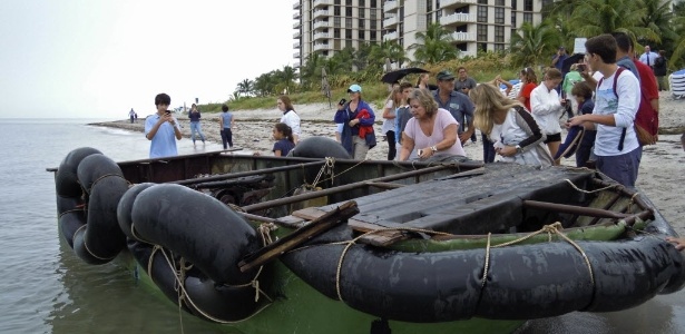 Moradores de Key Biscayne, na cidade de Miami (EUA), observam um barco improvisado que chegou de Cuba com nove pessoas a bordo