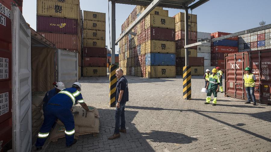 Funcionários abrem sacos em contêiner no porto de Santos em ação contra tráfico de drogas
